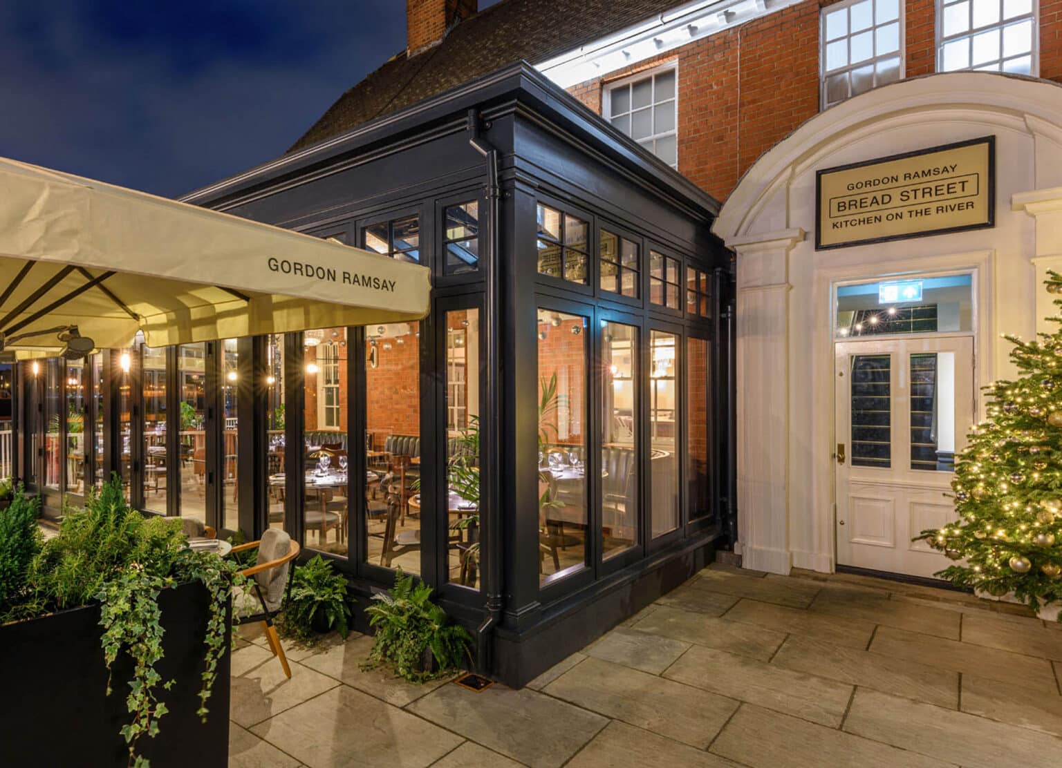 Bespoke conservatory entrance for a commercial bar or restaurant, illuminated at night.