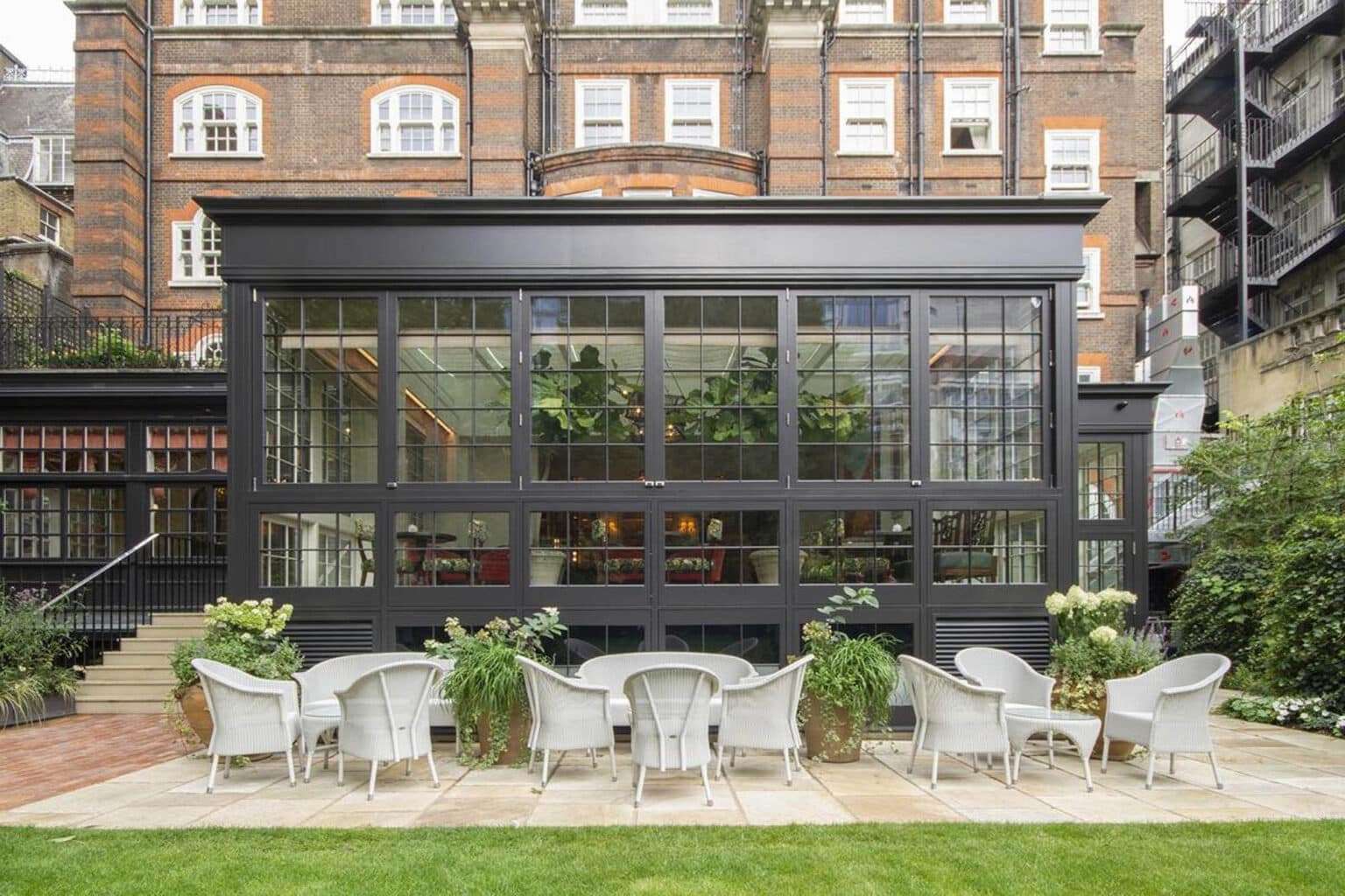 Commercial bar or restaurant with a large glass extension and garden seating.