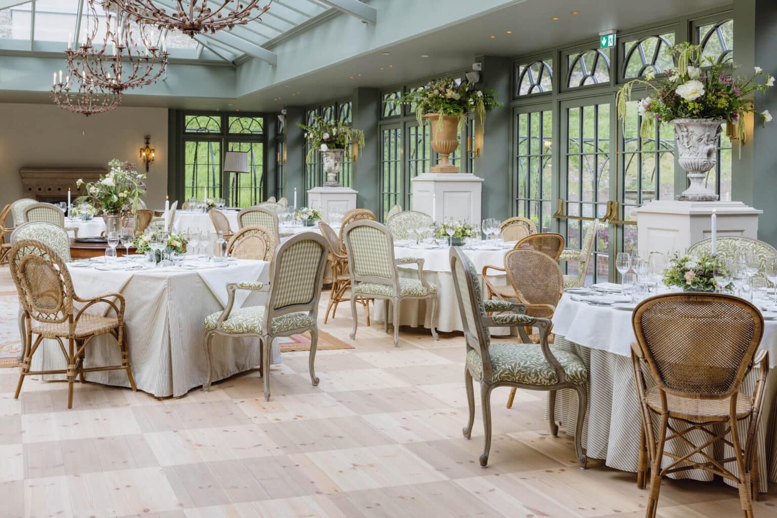 Commercial orangery interior used as a bright, formal dining space for a hotel.