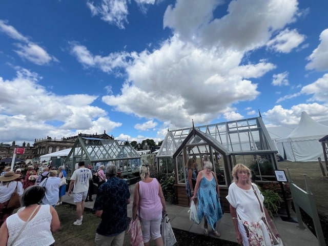 Crowds of RHS show visitors in front of the Hampton greenhouse display models.