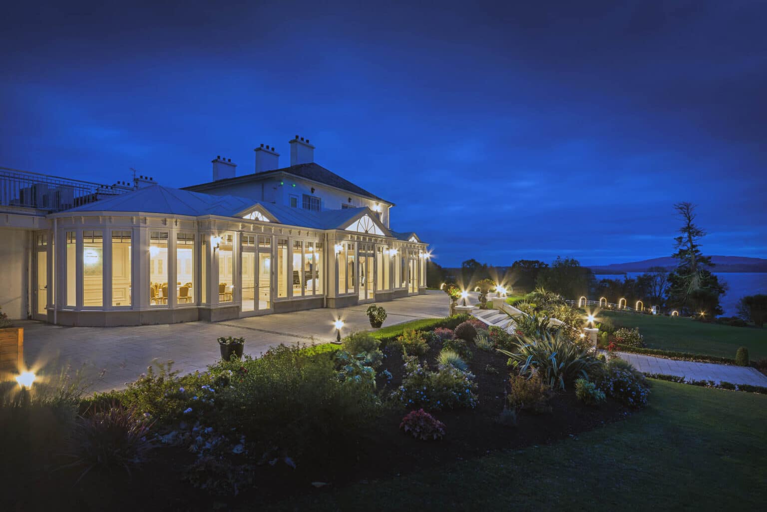 Bespoke glazed extension for a commercial venue, viewed at dusk.