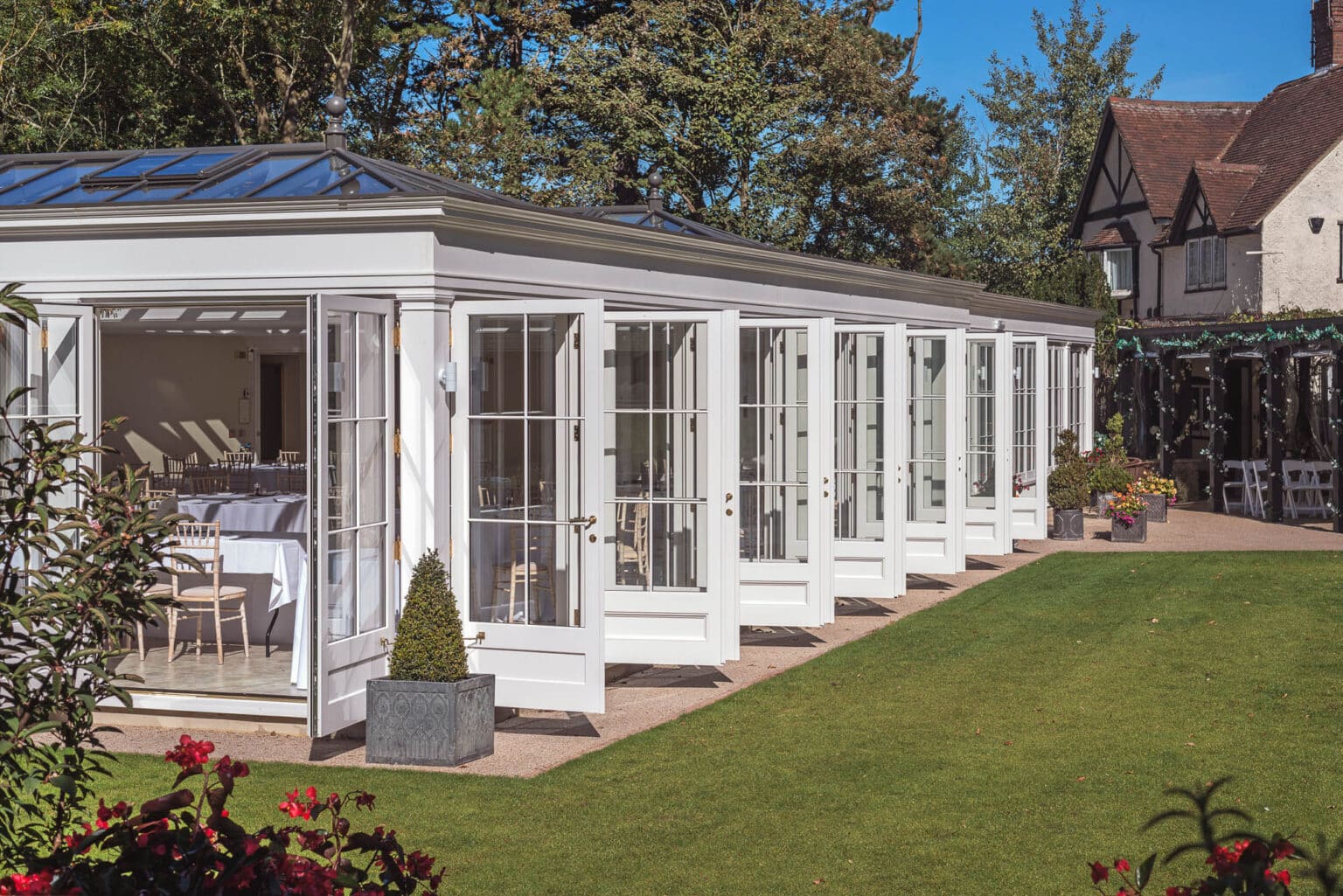 Long, white hardwood conservatory for a commercial wedding venue.