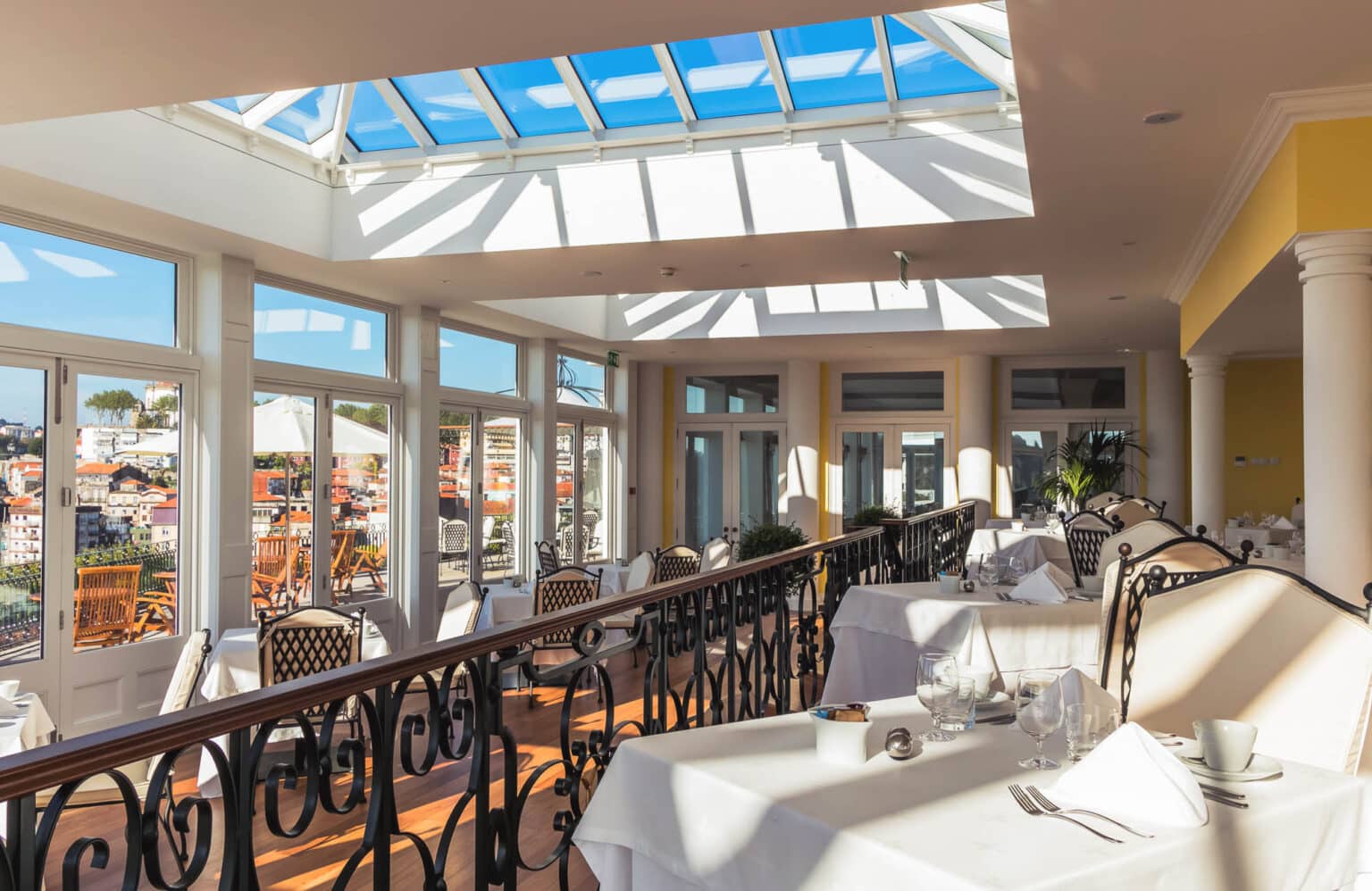 Bright interior of a commercial restaurant, lit by a large roof lantern.