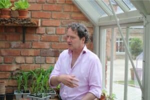 Diarmuid Gavin standing in a greenhouse.